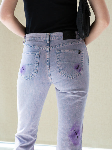 Woman wearing vintage 2000s lilac overdyed jeans with faux 'visible mending' detailing