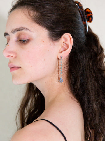 Woman wearing a pair of vintage Y2K light-blue diamanté earrings with a crystal bead drop.