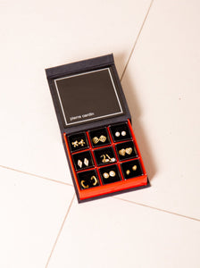 A vintage Pierre Cardin gift set containing nine pairs of gold-tone stud earrings in a black and red box