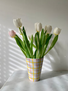 A vintage ceramic vase with hand-painted pink and yellow gingham design on a white glaze