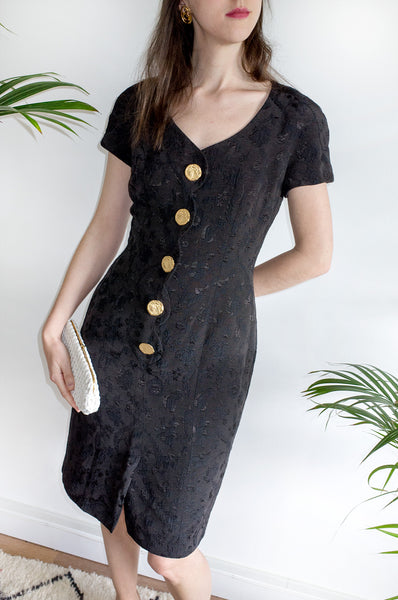 A vintage 1980s black fitted formal dress with scalloped detailing at front and oversized gold buttons