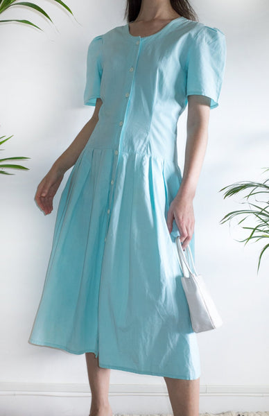 Woman wearing a vintage aqua-blue cotton day dress from the 1980s.