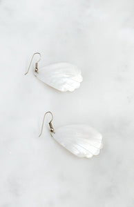 Mother-of-pearl shell earrings with engraved scalloped-edge design and silver-tone wire fastening.