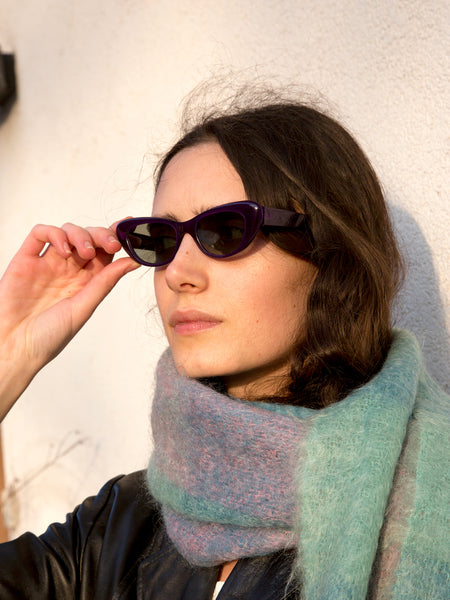 Woman wearing vintage 1960s purple narrow cat-eye sunglasses.