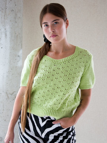 Woman wearing a vintage lime-green hand-knitted short-sleeve jumper.